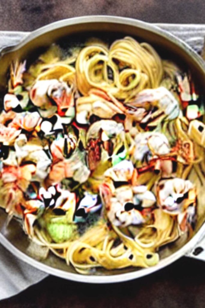 aerial view of white serving dish with shrimp and chicken carbonara pasta on white gray dish towel