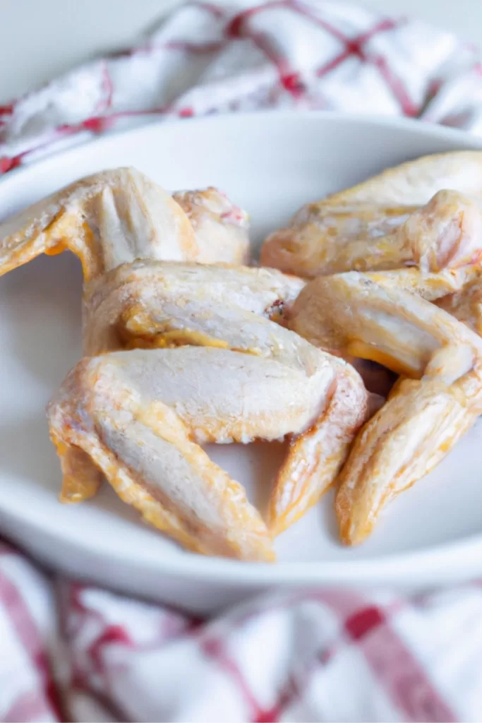 raw chicken wings on a white plate